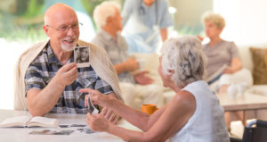 An older man shows an older woman a photograph of a young person