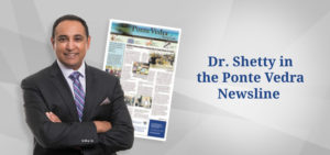 Dr. Shetty smiles with his arms crossed. An image of the Ponte Vedra Newsline is behind him. Text to his right reads "Dr. Shetty in the Ponte Vedra Newsline"