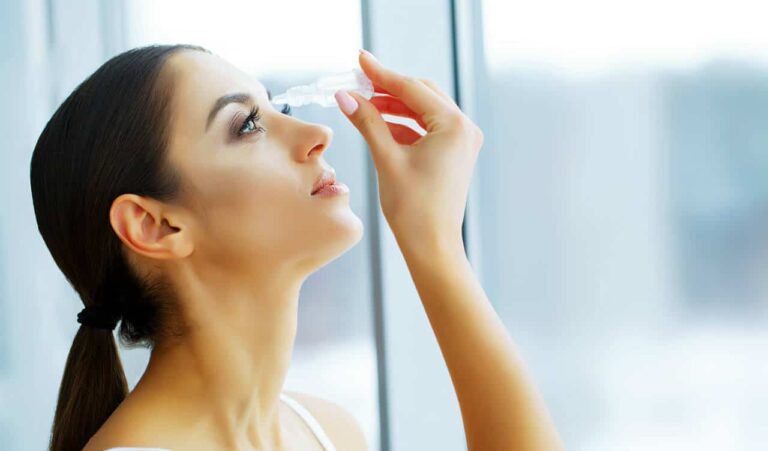 Woman using an eyedropper to drop eye drops into her eye