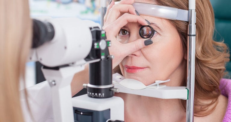 Professional female ophthalmologist is checking human eyes