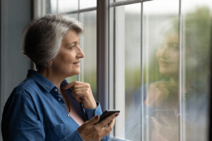 A senior woman looks out the window