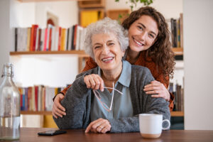 A senior woman and her daughter smile