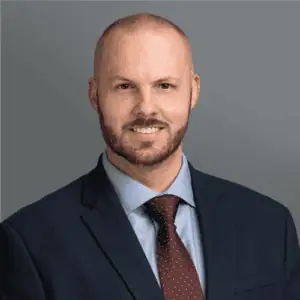Headshot of Dr. Norman's in professional wear with a grey background.