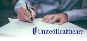 Someone's hands sign a document. The United Healthcare logo is featured at the bottom of the image