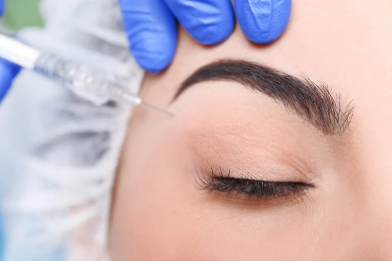 close up of woman getting injection under eye brow, eye closed