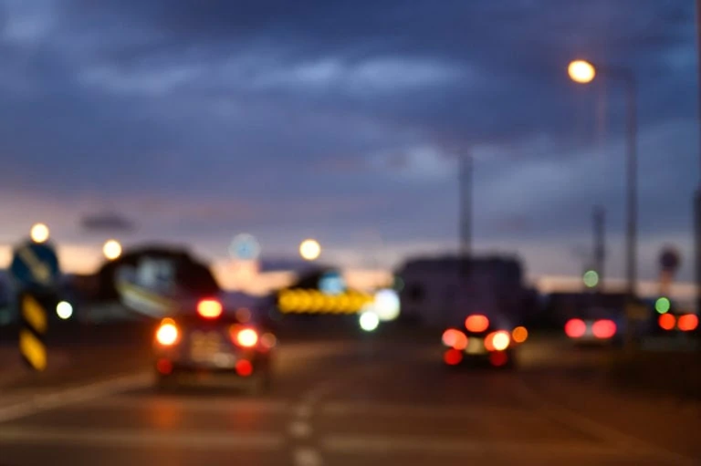 Bokeh cars and traffic lights on highway at night