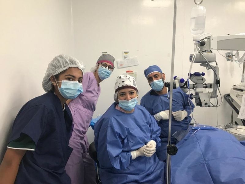 Dr. Chokshi, his daughter and other surgical staff smile in a surgery room