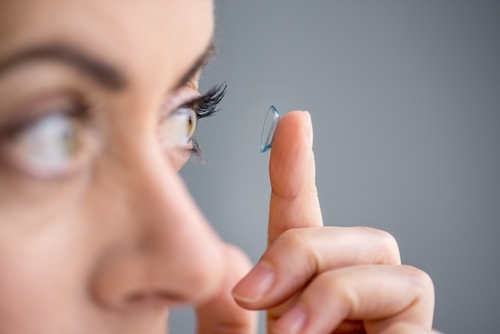 Woman putting in contact lens.