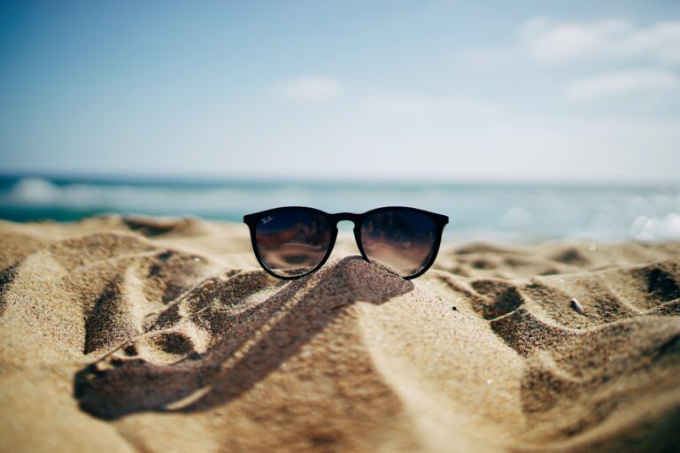 sunglasses laying in sand on beach